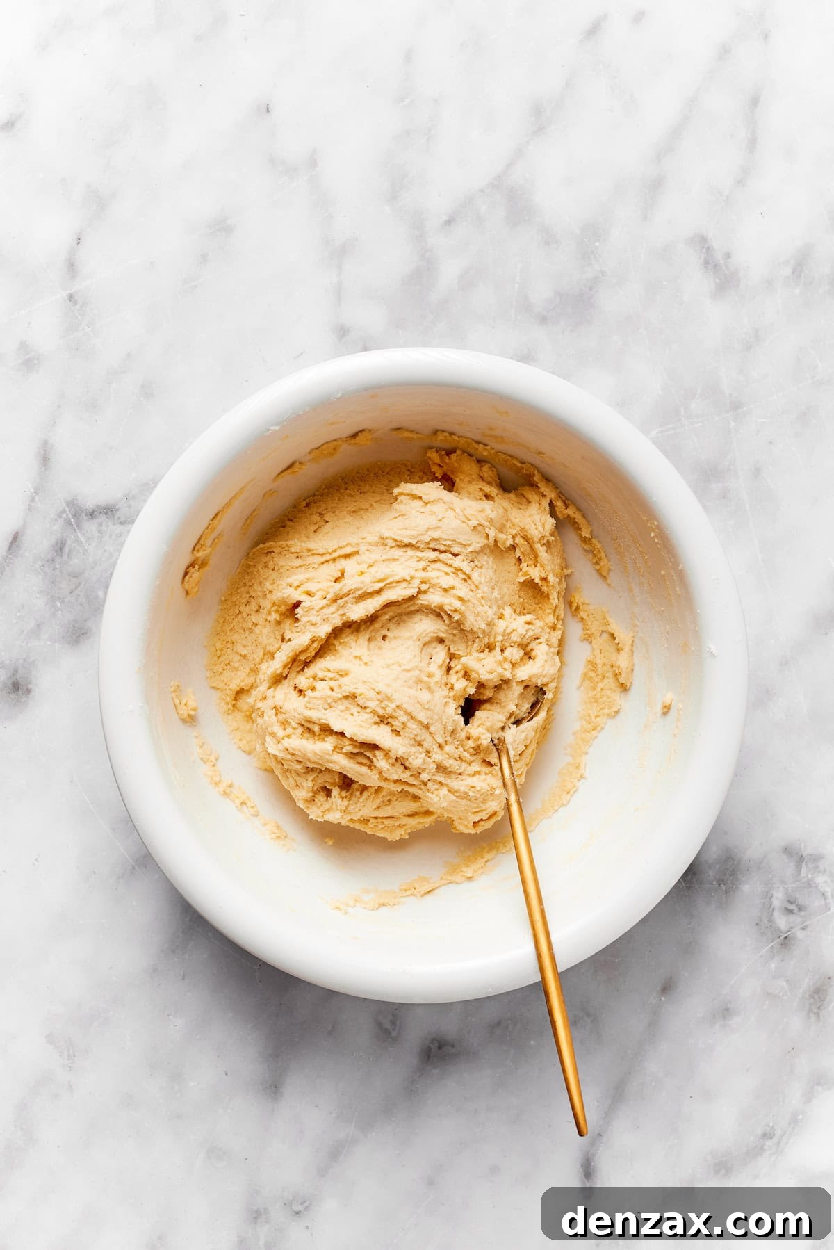 A bowl of anginetti cookie dough with a spoon.