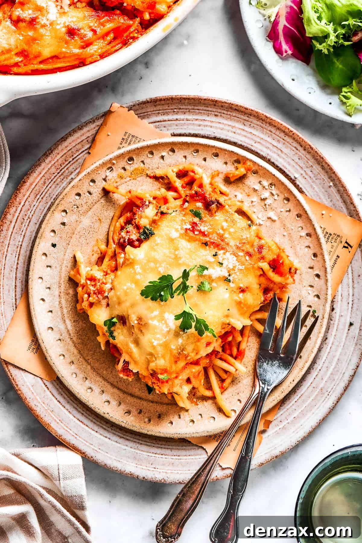A serving of million dollar spaghetti served on a plate with forks.