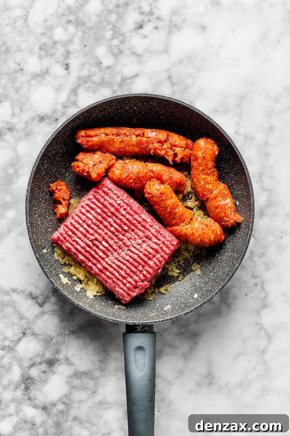 Adding ground beef and sausage to the skillet.