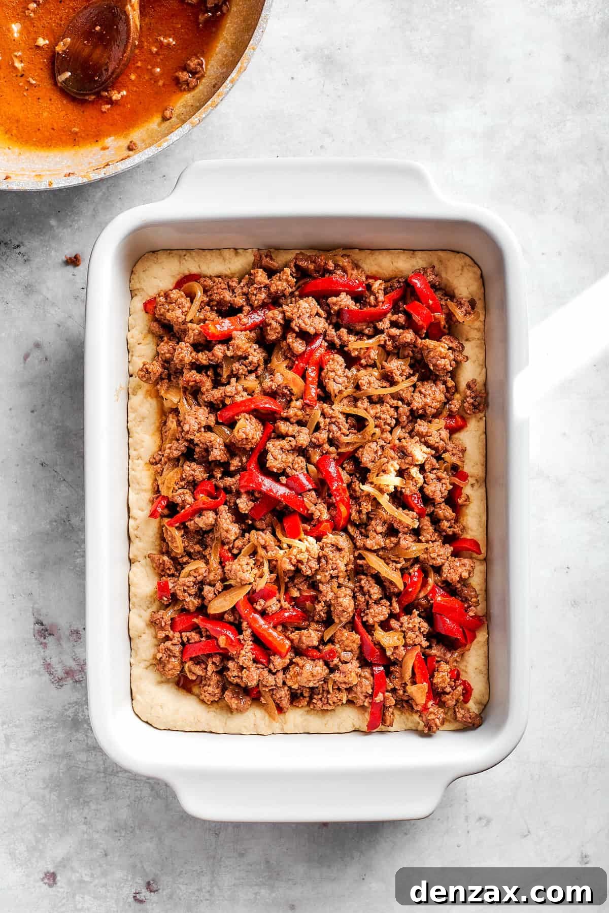 Add meat to the dish. Add cooked beef filling to baking dish.