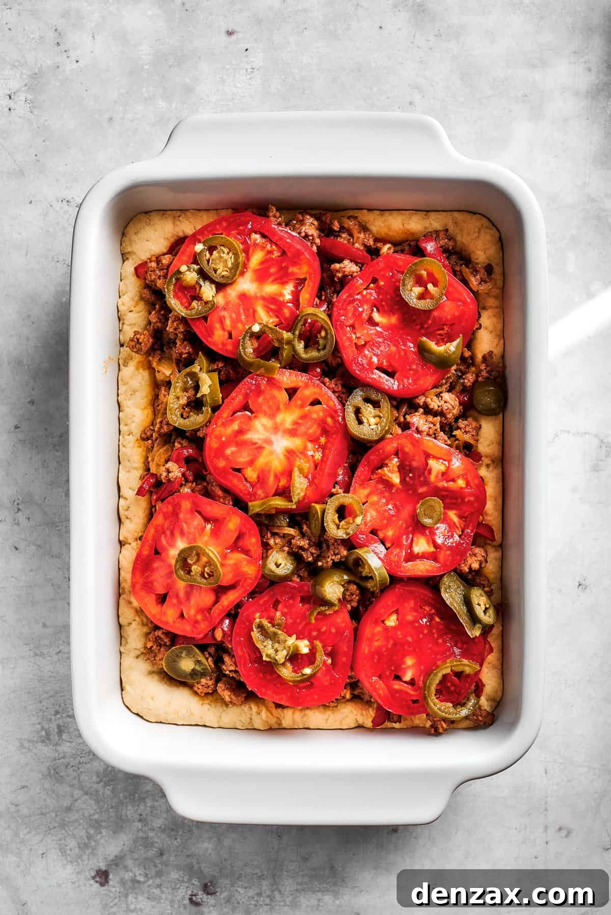 Layer tomato slices. Tomato slices over meat and potatoes.