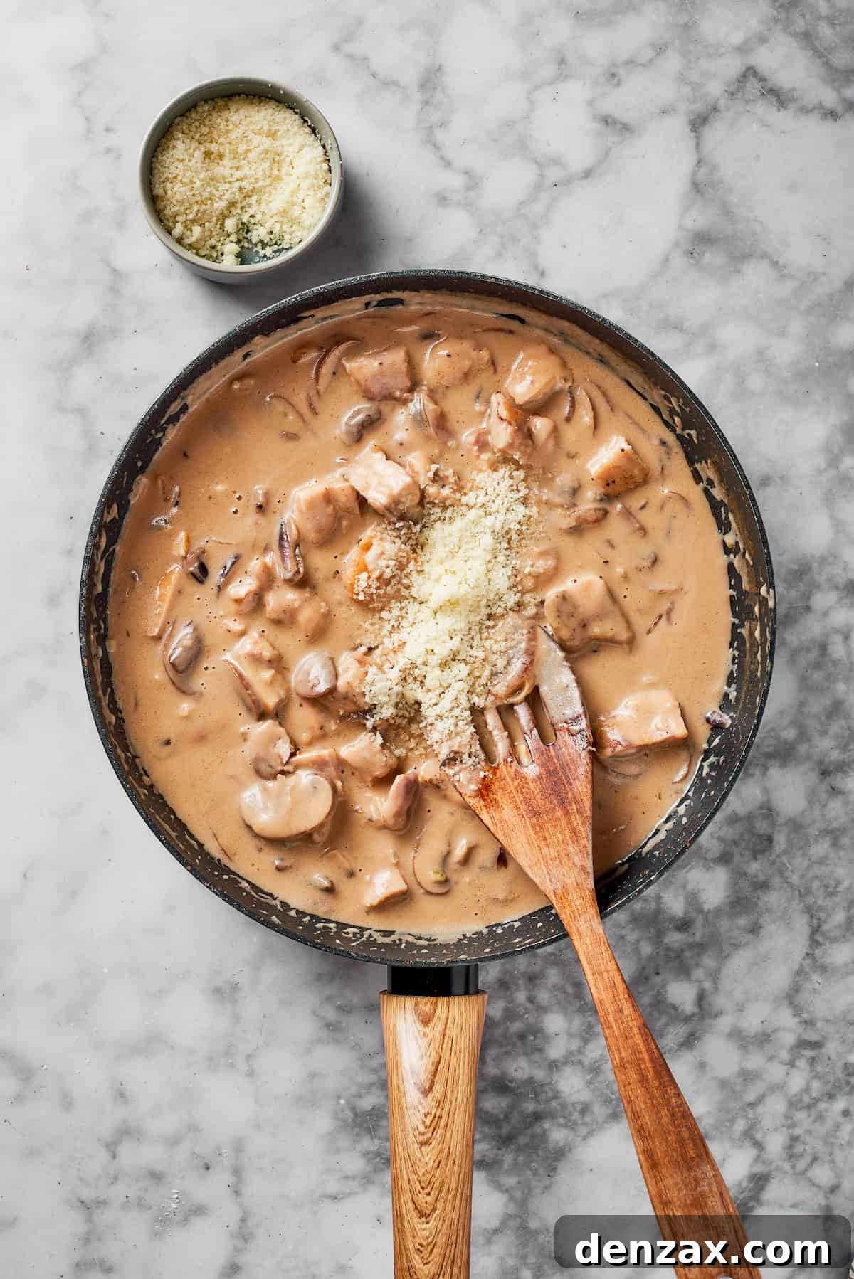 Adding chicken and cheese to the skillet.