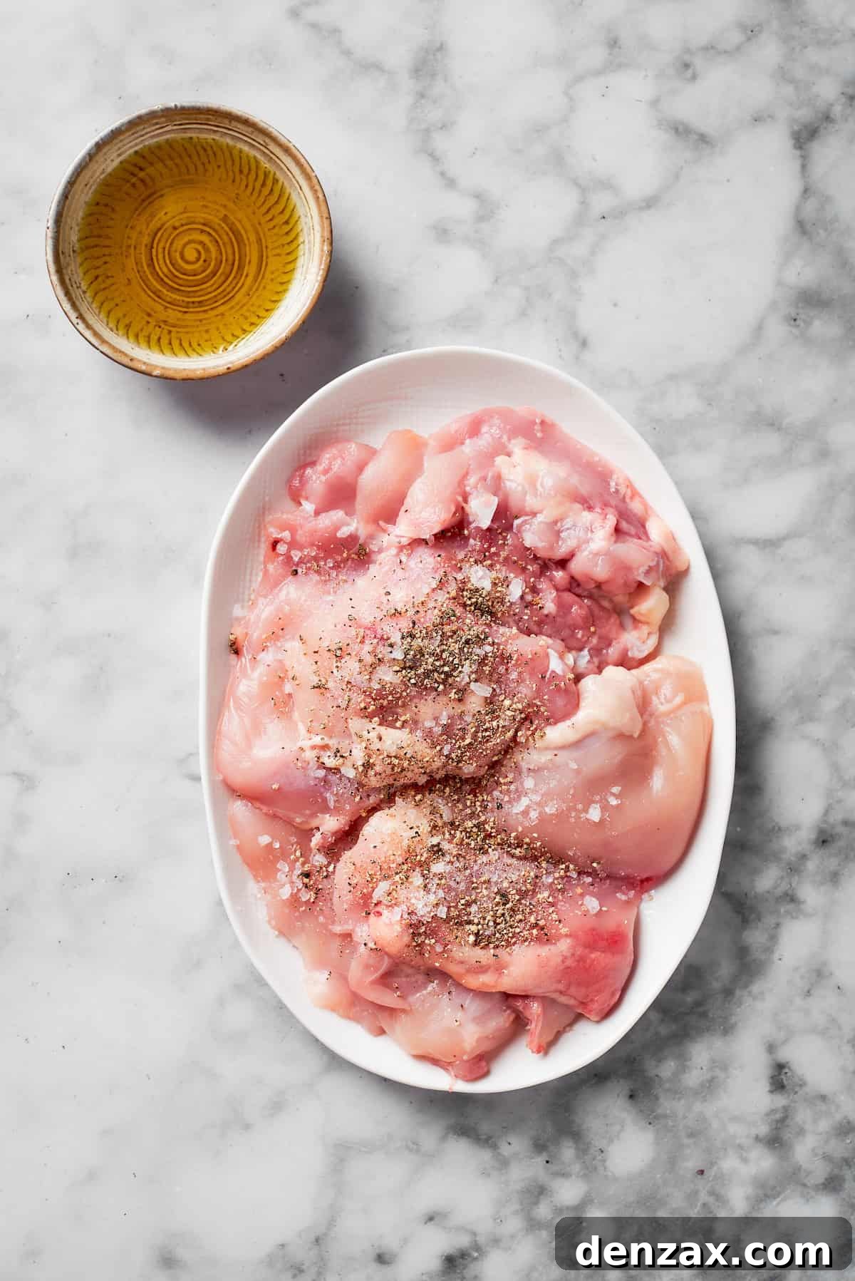 Seasoned chicken breasts on a plate.