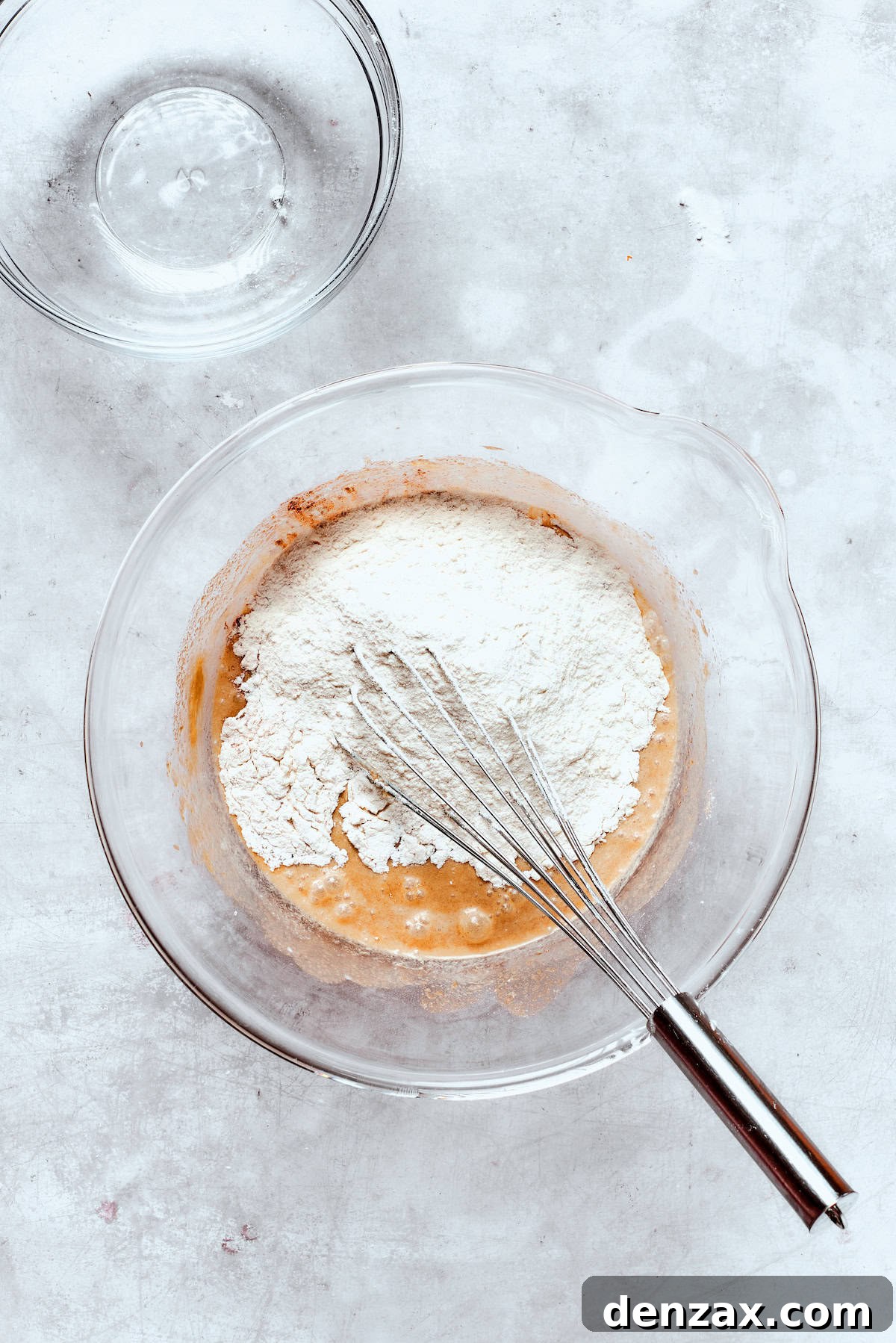 Whisking in dry ingredients to donut batter.