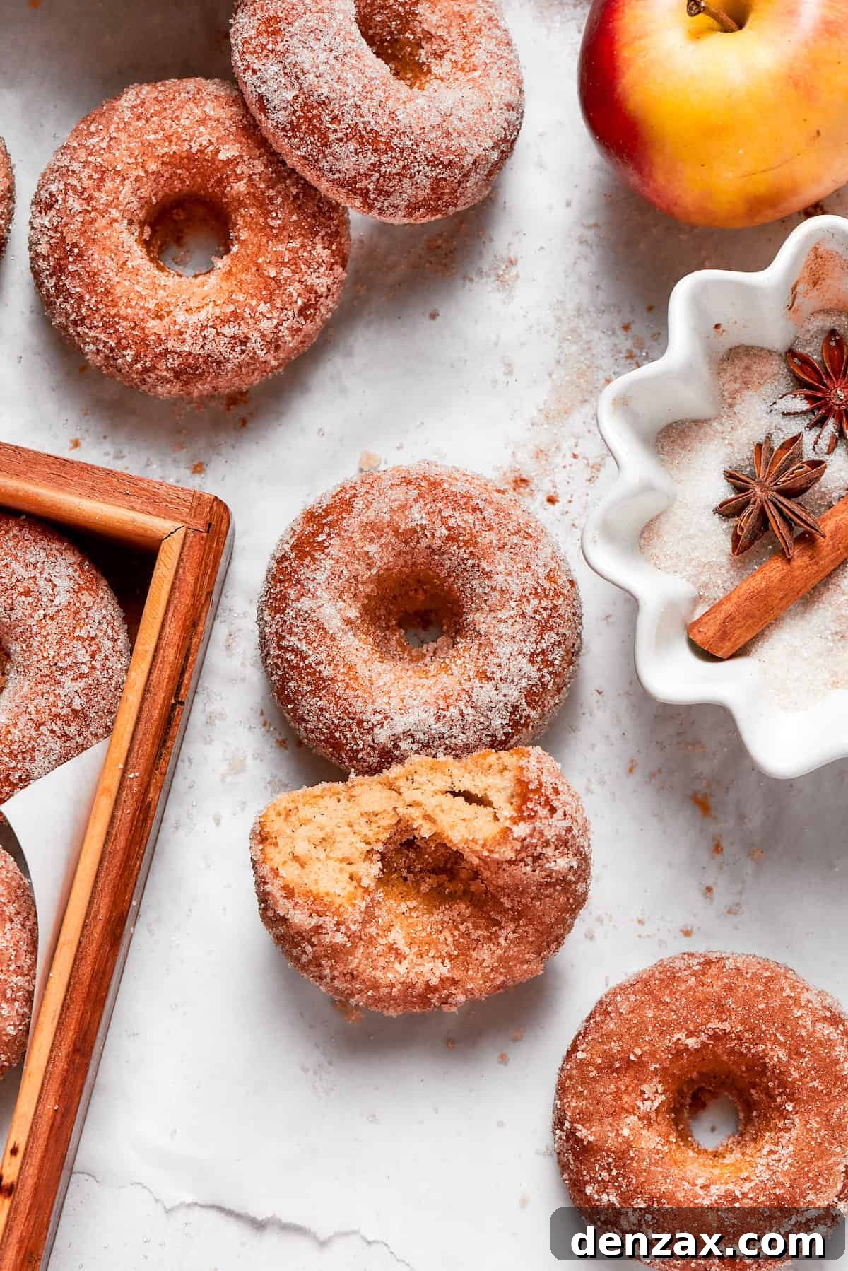 Apple cider donuts, one with a bite taken out.