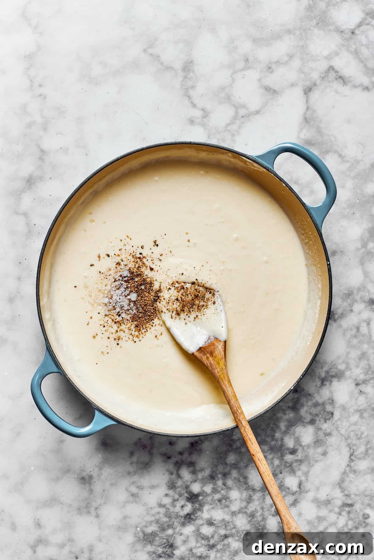 Adding seasonings to a creamy pasta sauce.