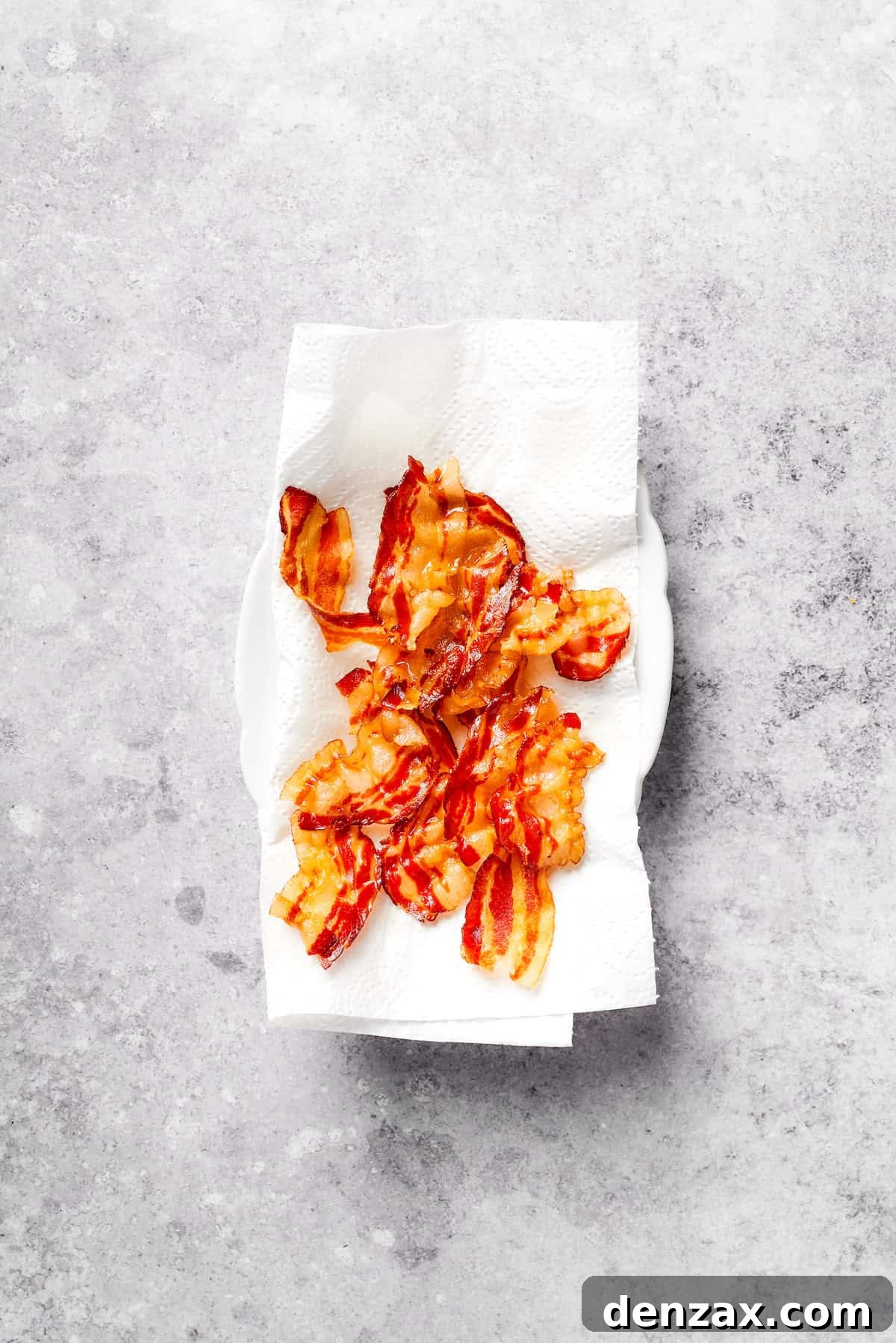 Cooked bacon drains on paper towels.