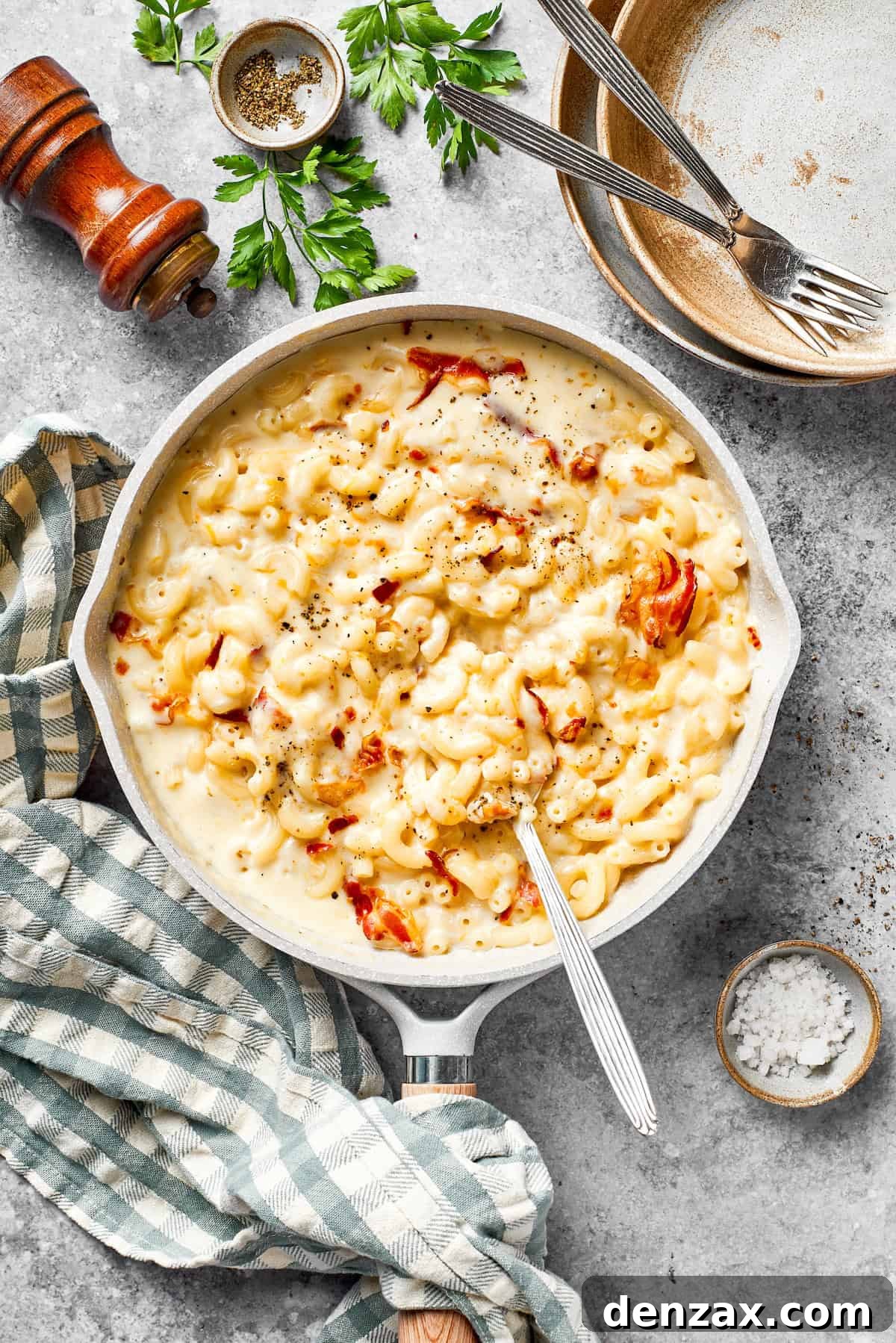 A pan of bacon mac and cheese and a spoon.