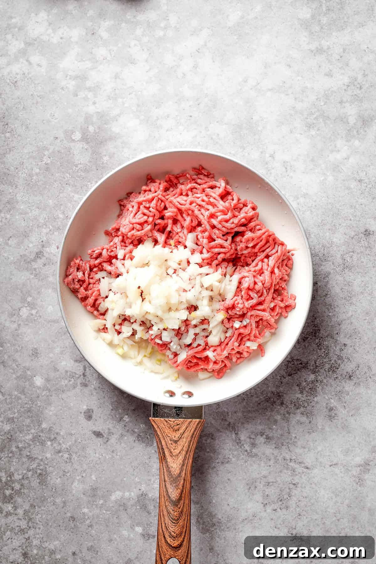 Ground beef and onion in a skillet.