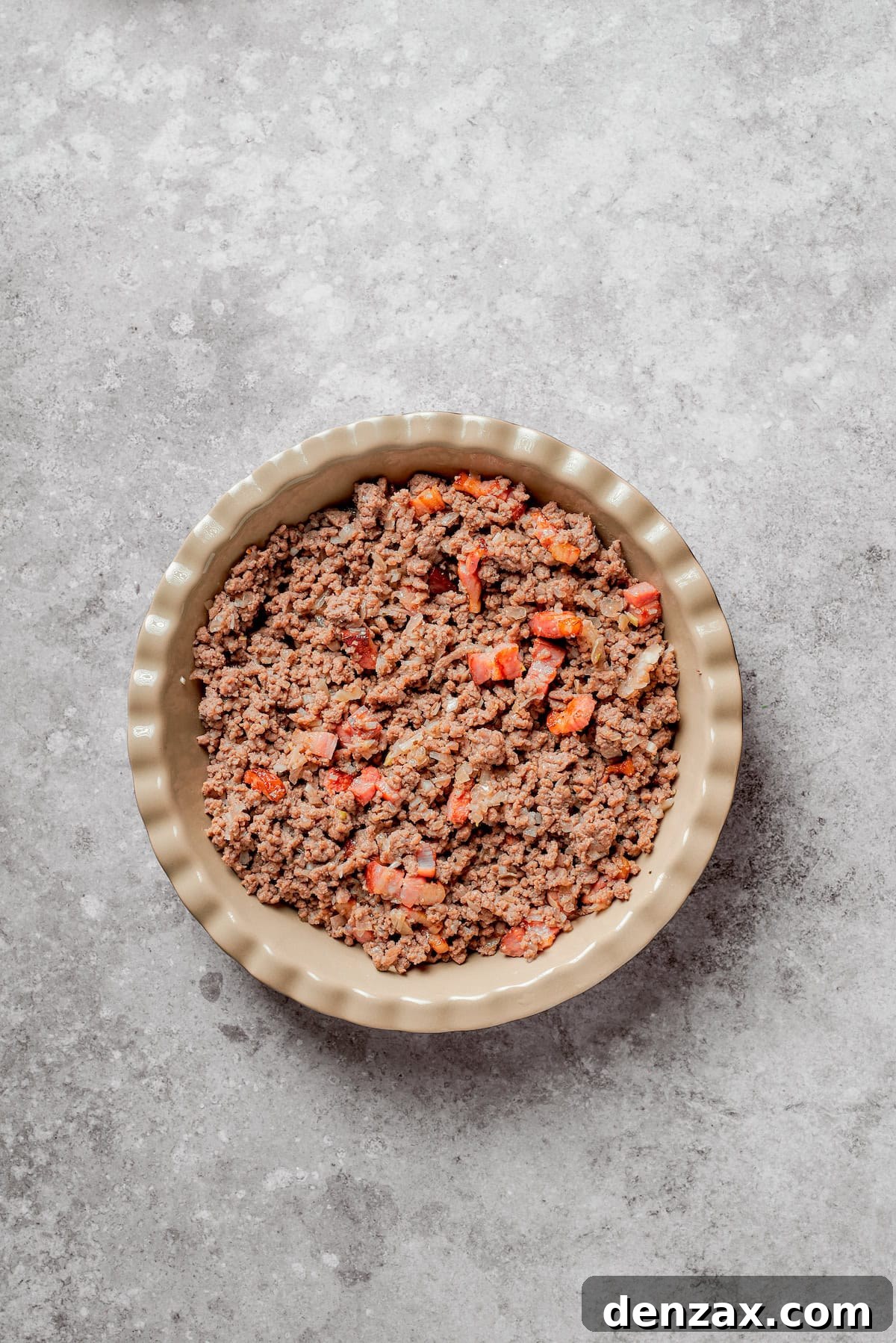 Cheeseburger pie filling in a pie pan.