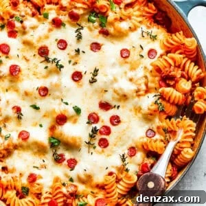 A big pan of pizza pasta topped with melted cheese and pepperoni.