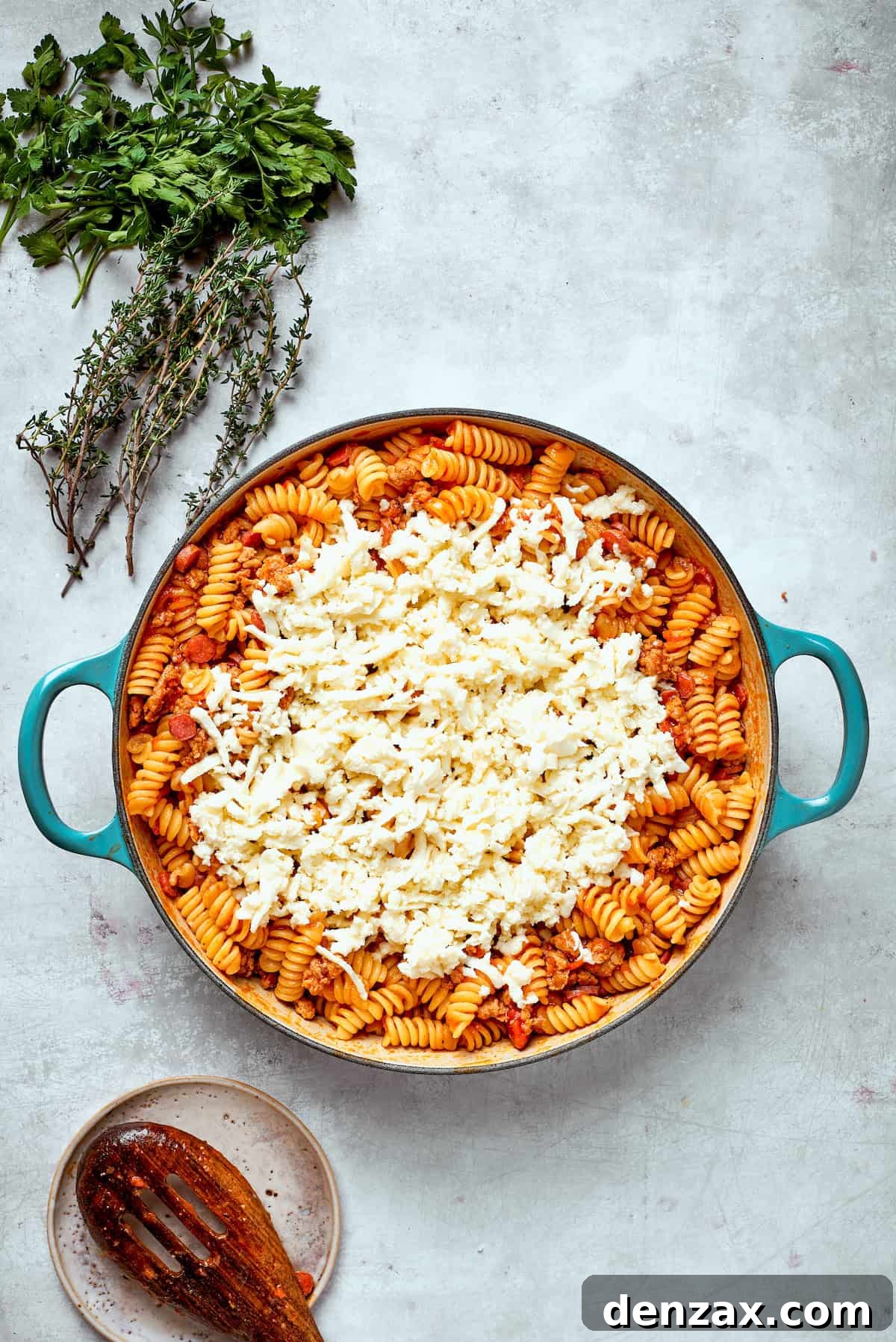 Cheese is added to a pan of pizza pasta.