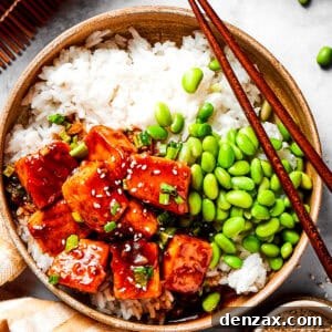 A bowl of white rice topped with cubed salmon and edamame.
