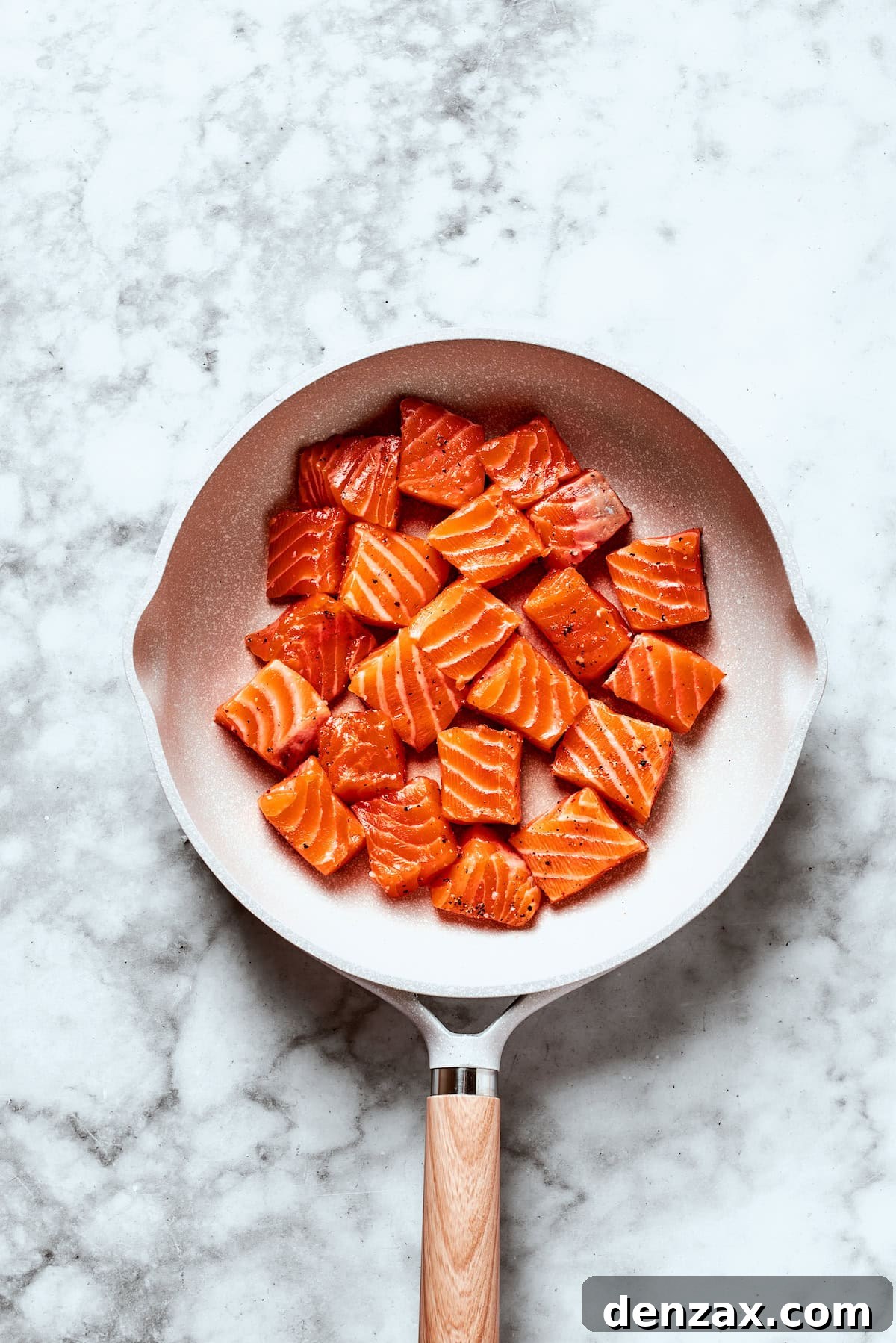 Salmon cubes in a skillet.
