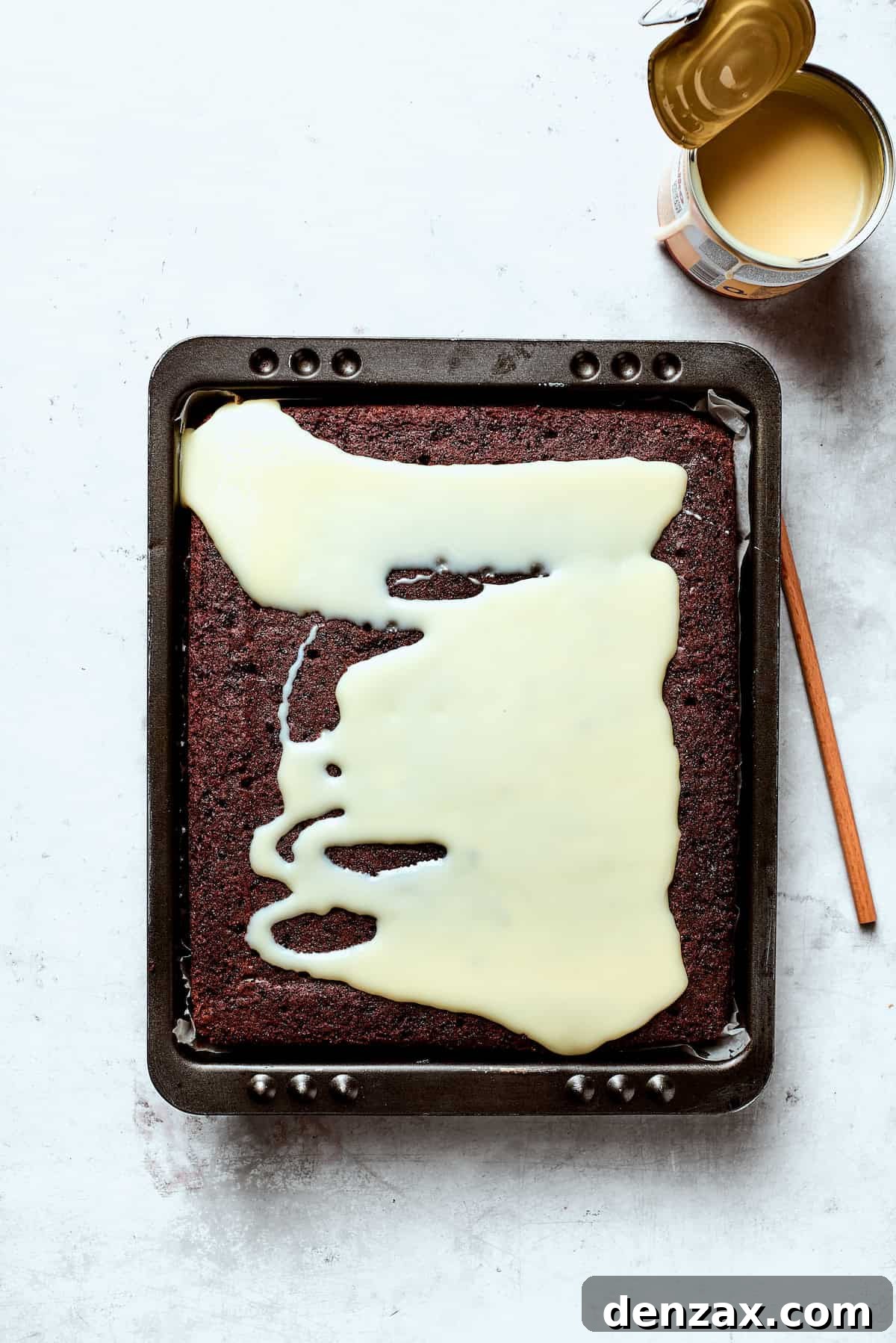 Condensed milk is poured over chocoalte cake.