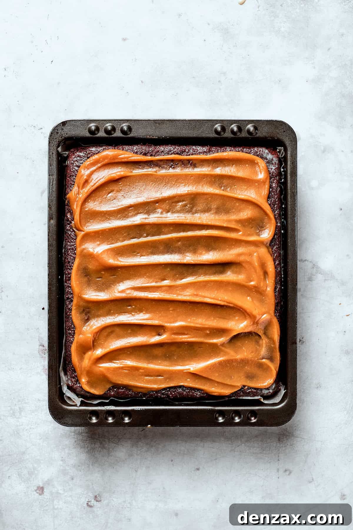 Caramel spread over the top of a chocolate cake.