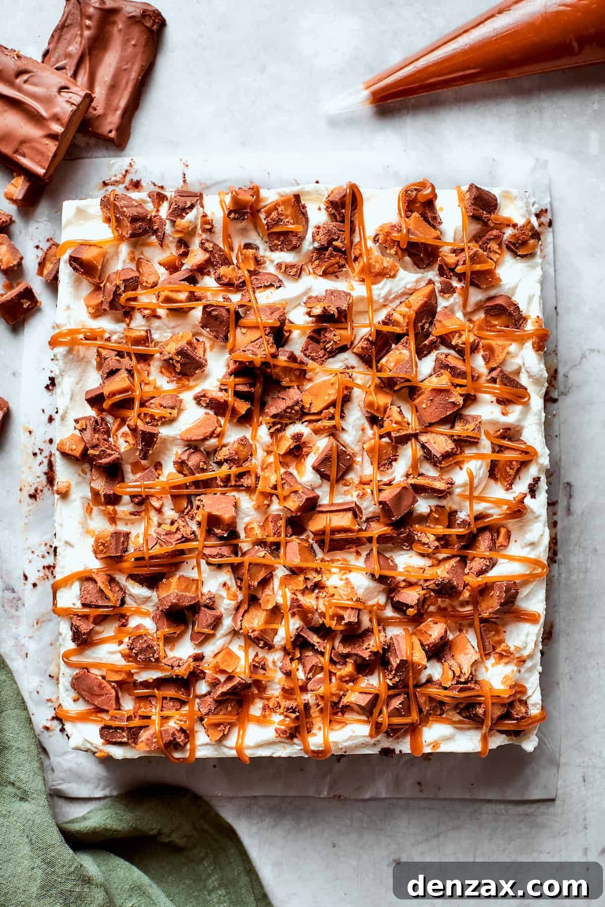 A better than sex cake topped with chopped candy bars.