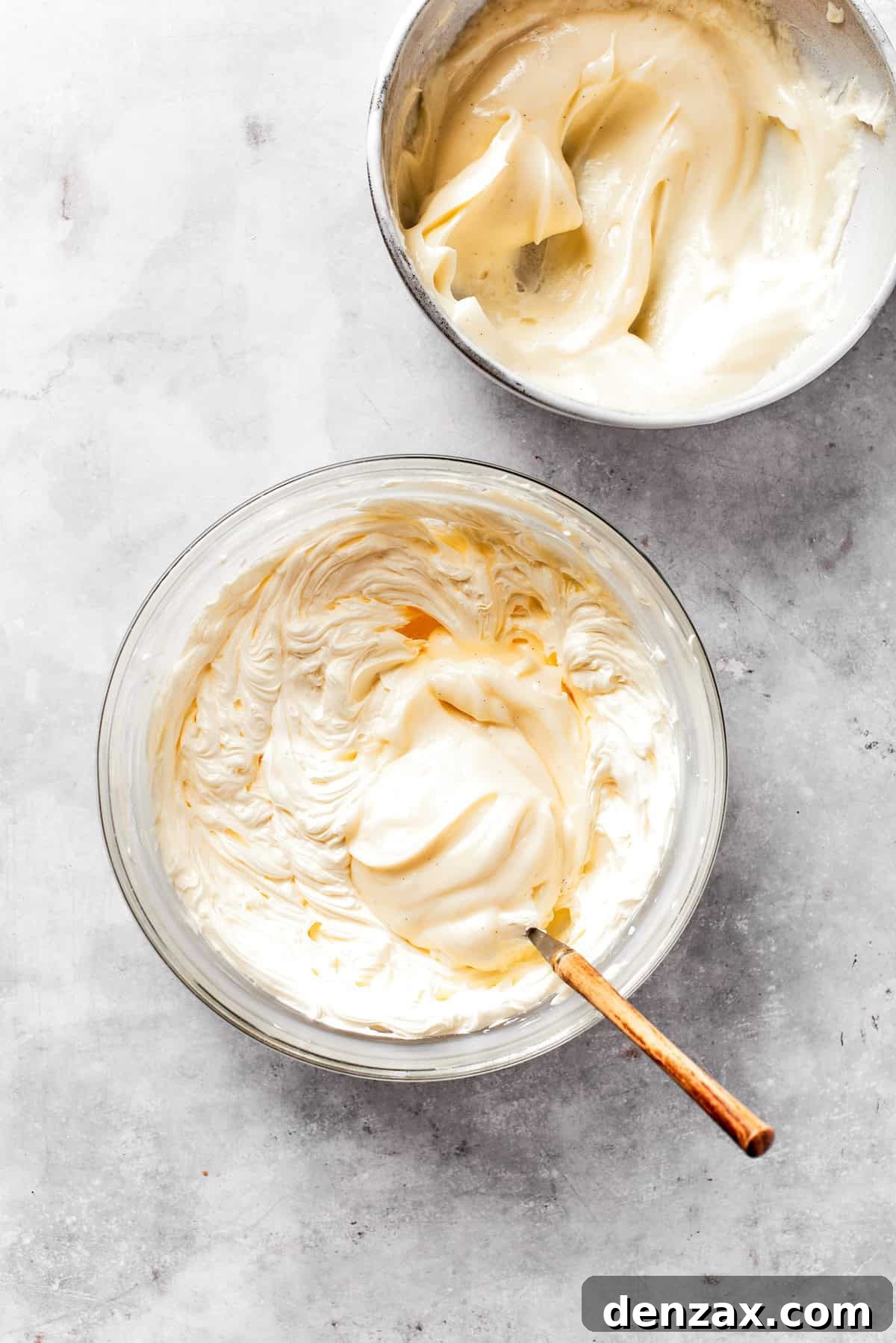 Cream cheese frosting is mixed in a bowl.