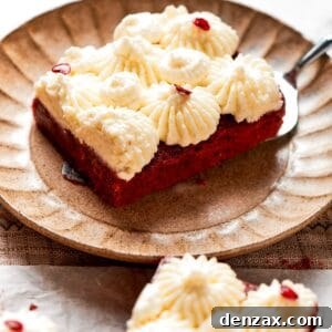 A red velvet brownie with frosting on a plate.