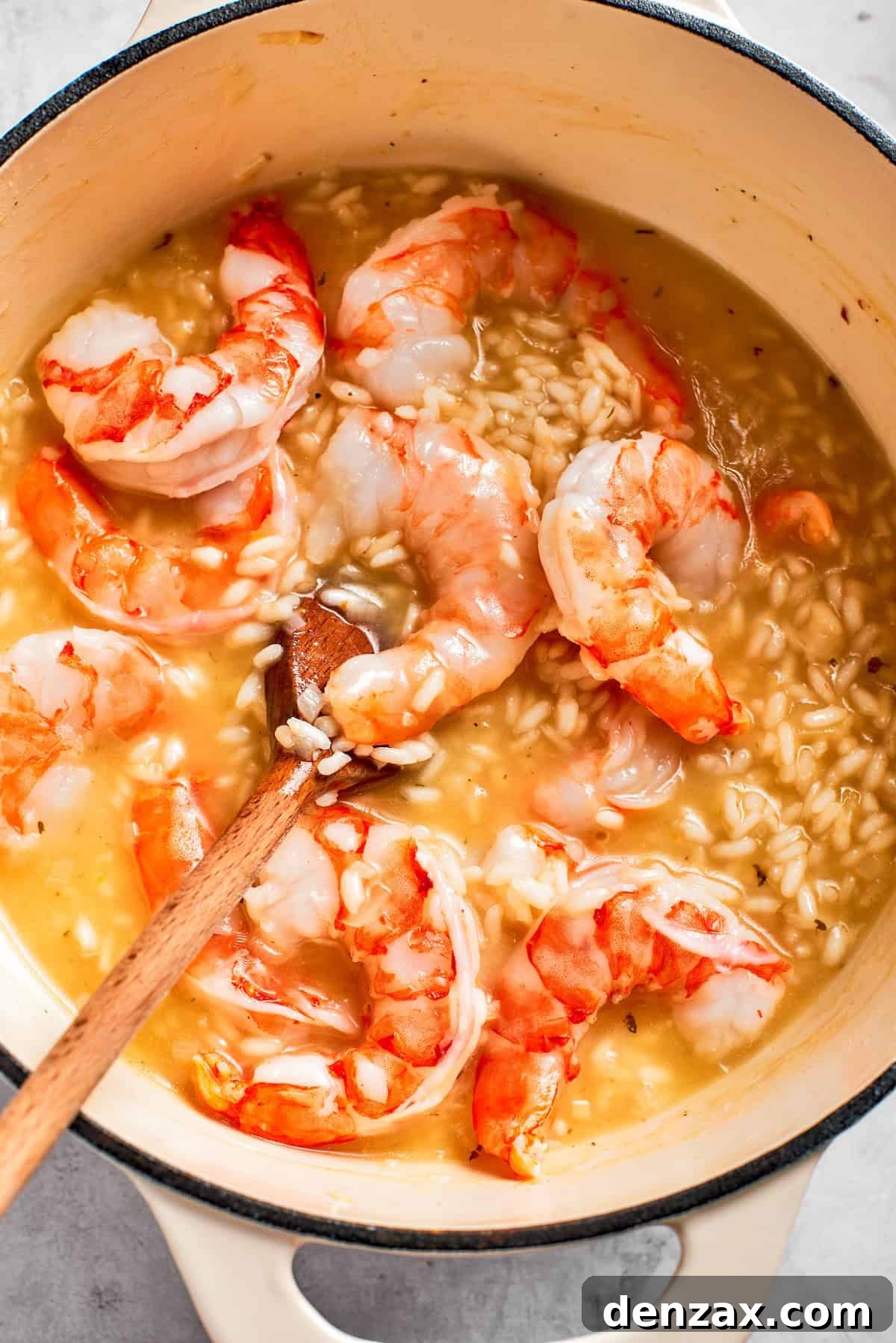 Shrimp cooks in a pot of risotto.
