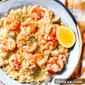 Shrimp risotto served on a plate with a wedge of lemon to the side.