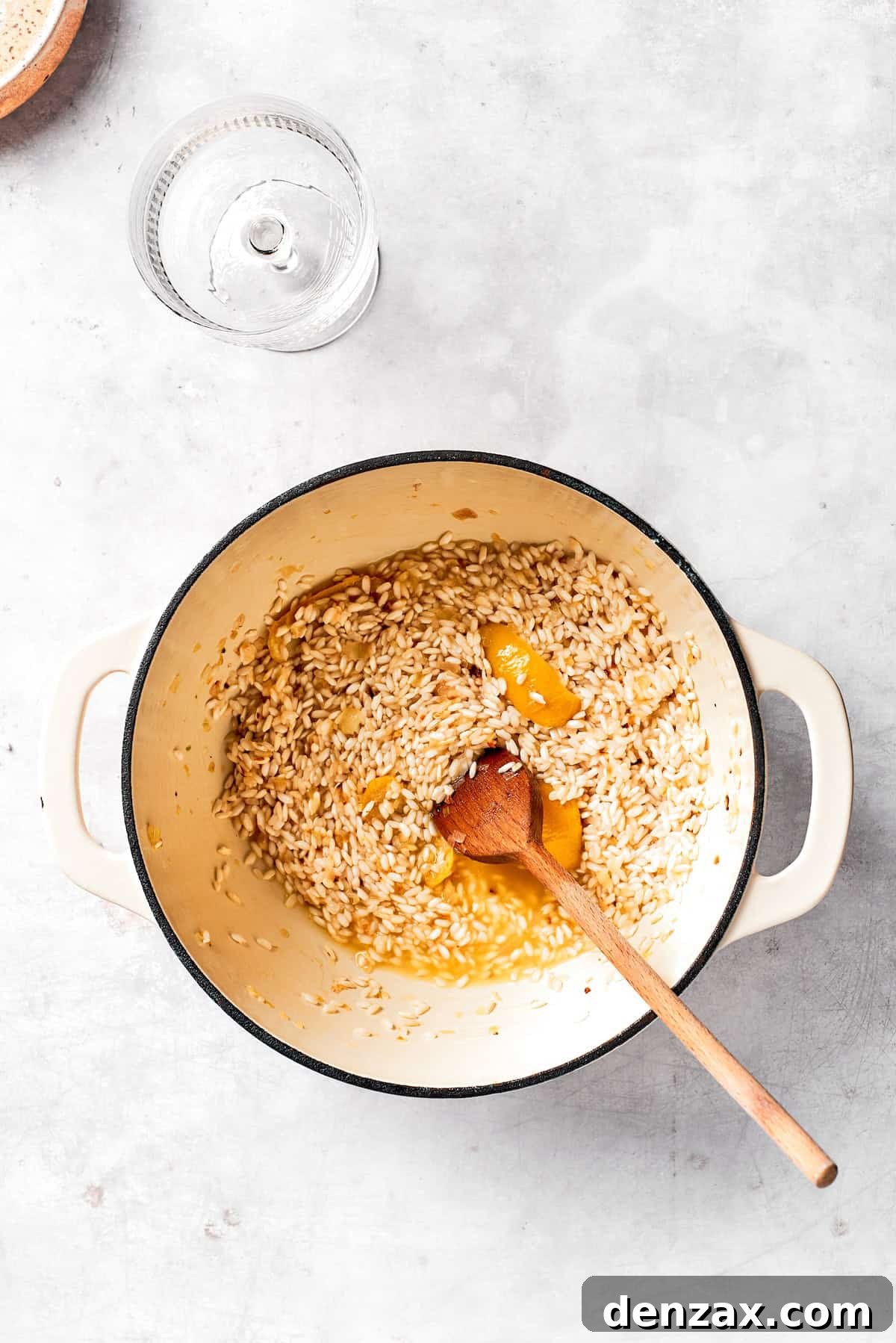 Stirring rice and garlic in a pot.