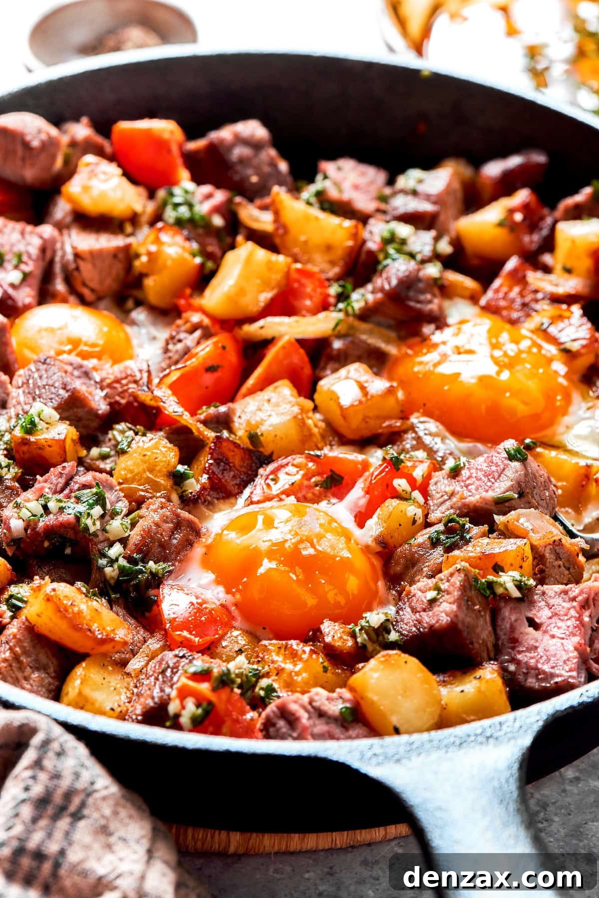 Fried eggs on top of a pan of steak and eggs.