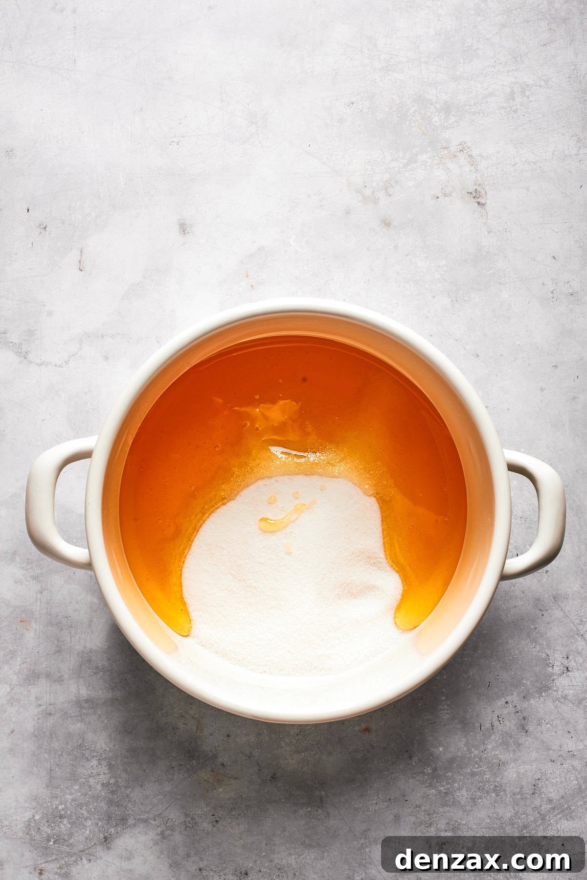 Sugar is added to a pot of melted butter.