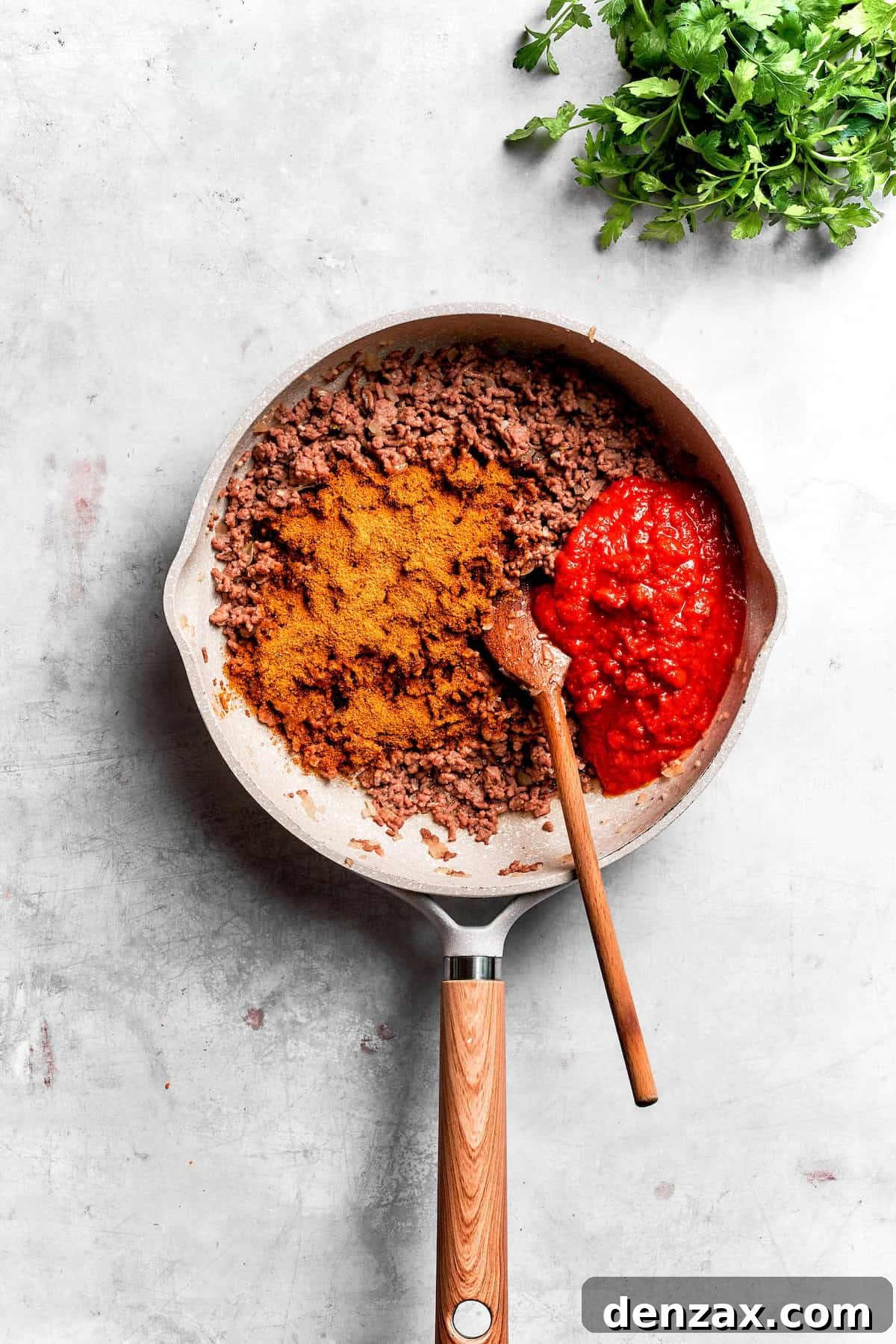 Beef browns in a skillet with taco seasoning.