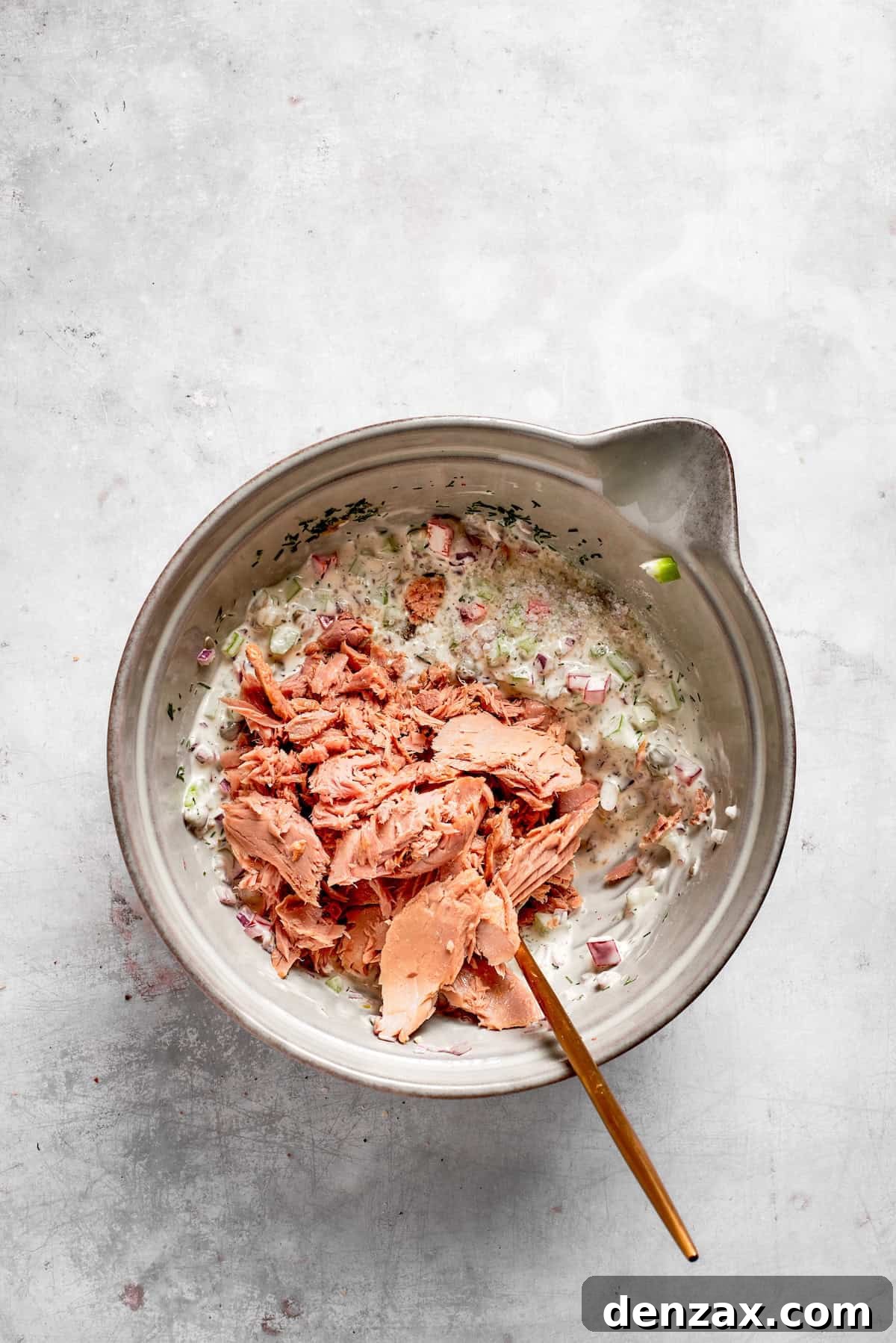 Tuna is added to tuna melt filling in a bowl.