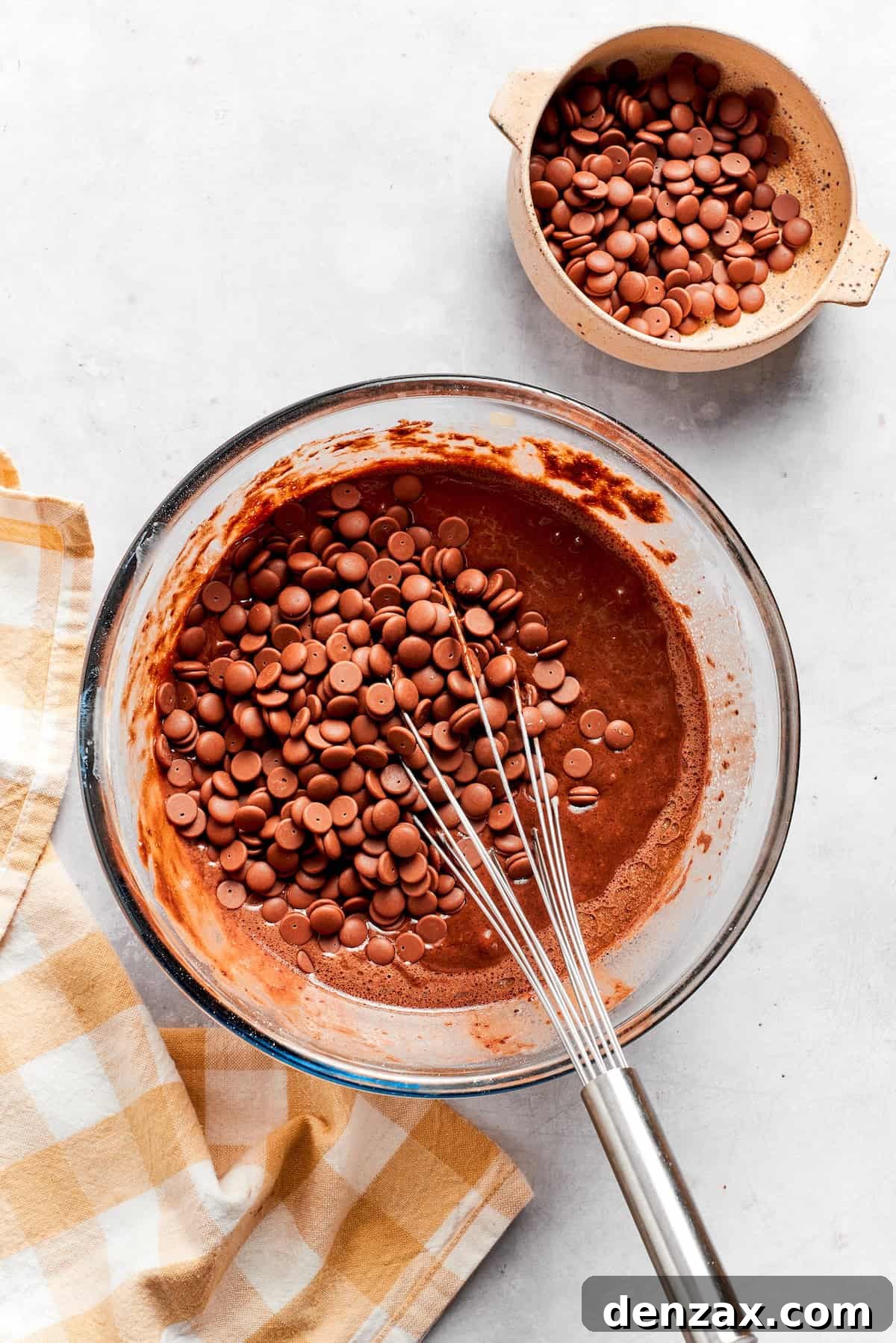 Chocolate chips are whisked into chocolate muffins batter.