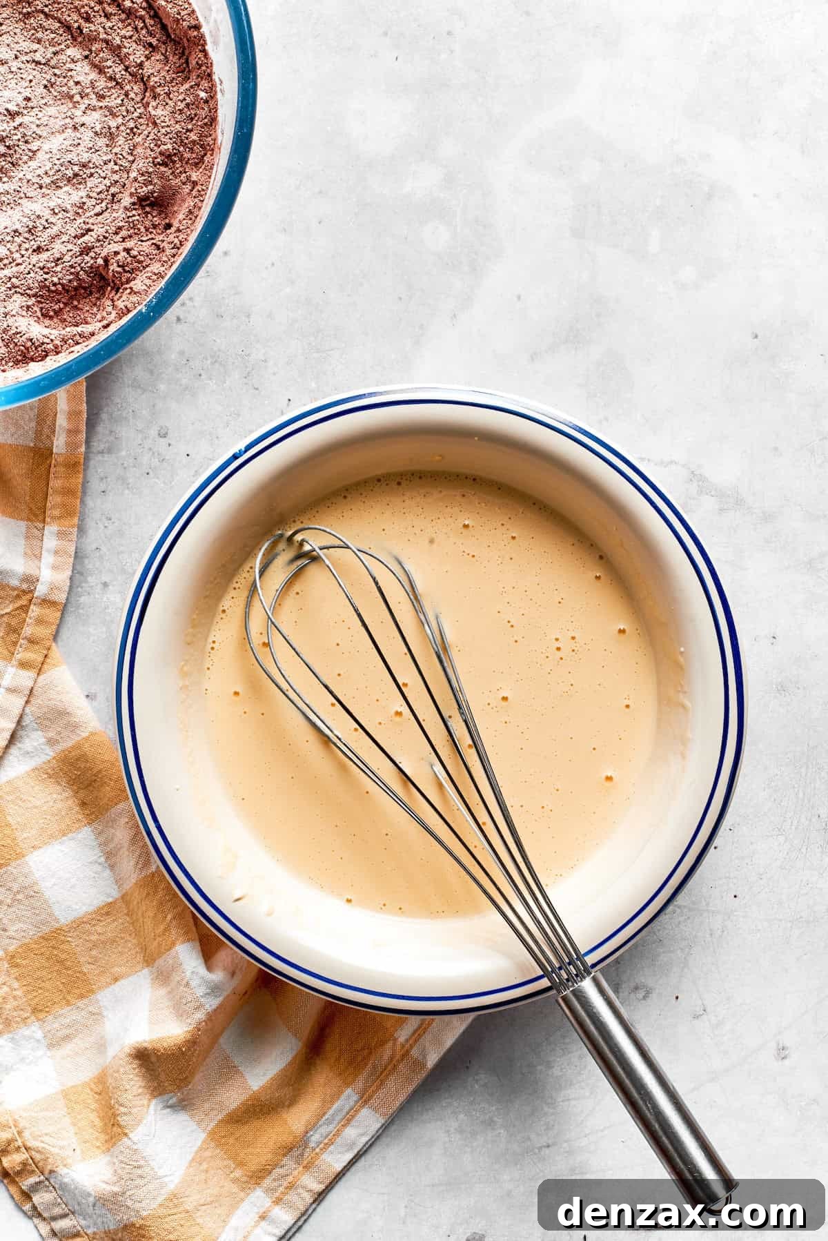 The wet mix for chocolate muffins in a bowl with a whisk.