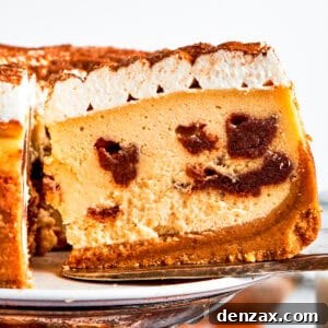 Exposing the cinnamon filling on a slice of a cinnamon roll cheesecake.