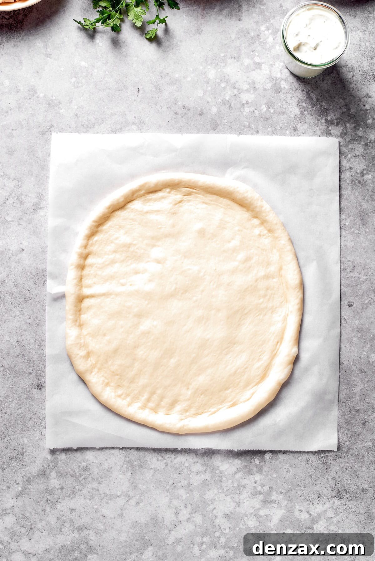 Pizza dough rolled out into a circle.