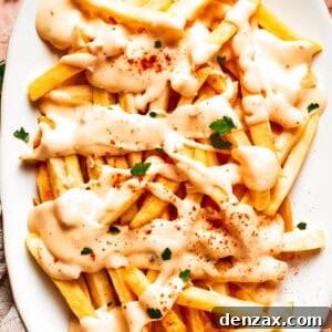 A platter of voodoo fries topped with cheese sauce.