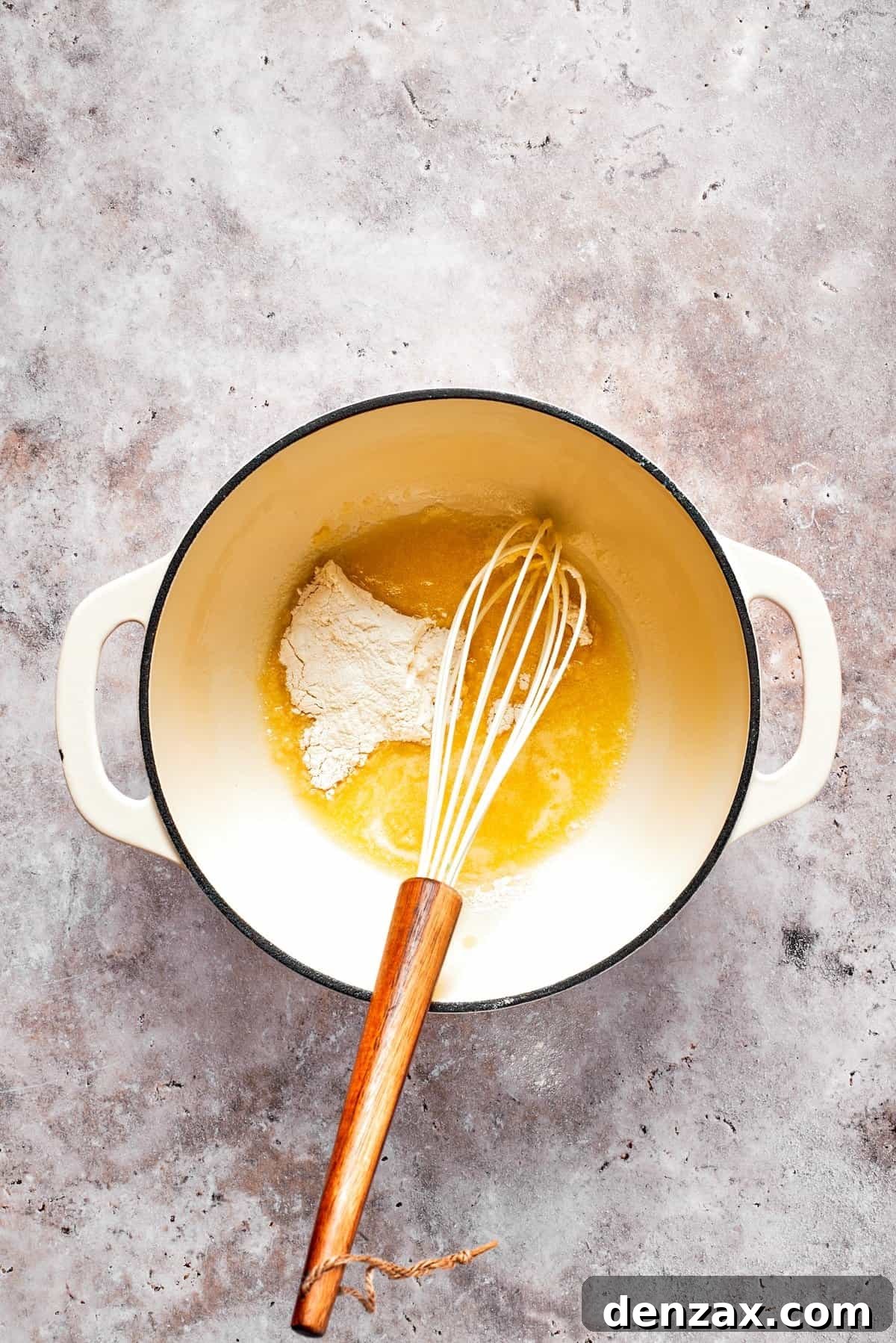 Butter and flour are combined in a pot to make a roux.