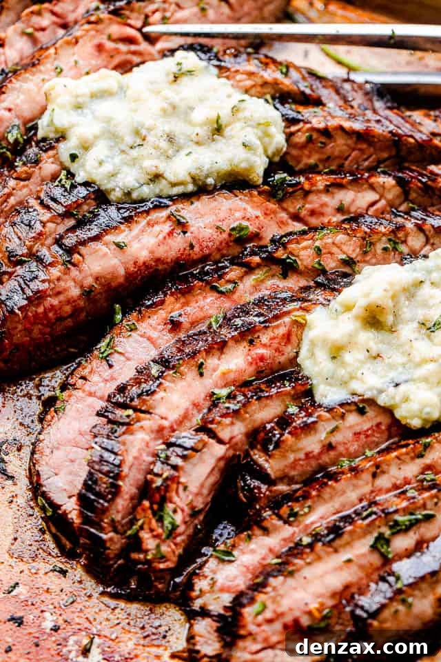close up side shot of sliced flank steak topped with compound butter