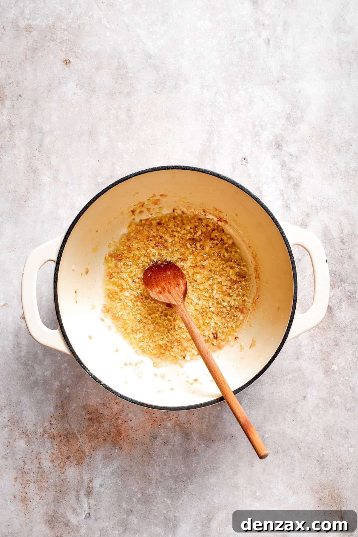 Aromatics are sauteed in a soup pot.