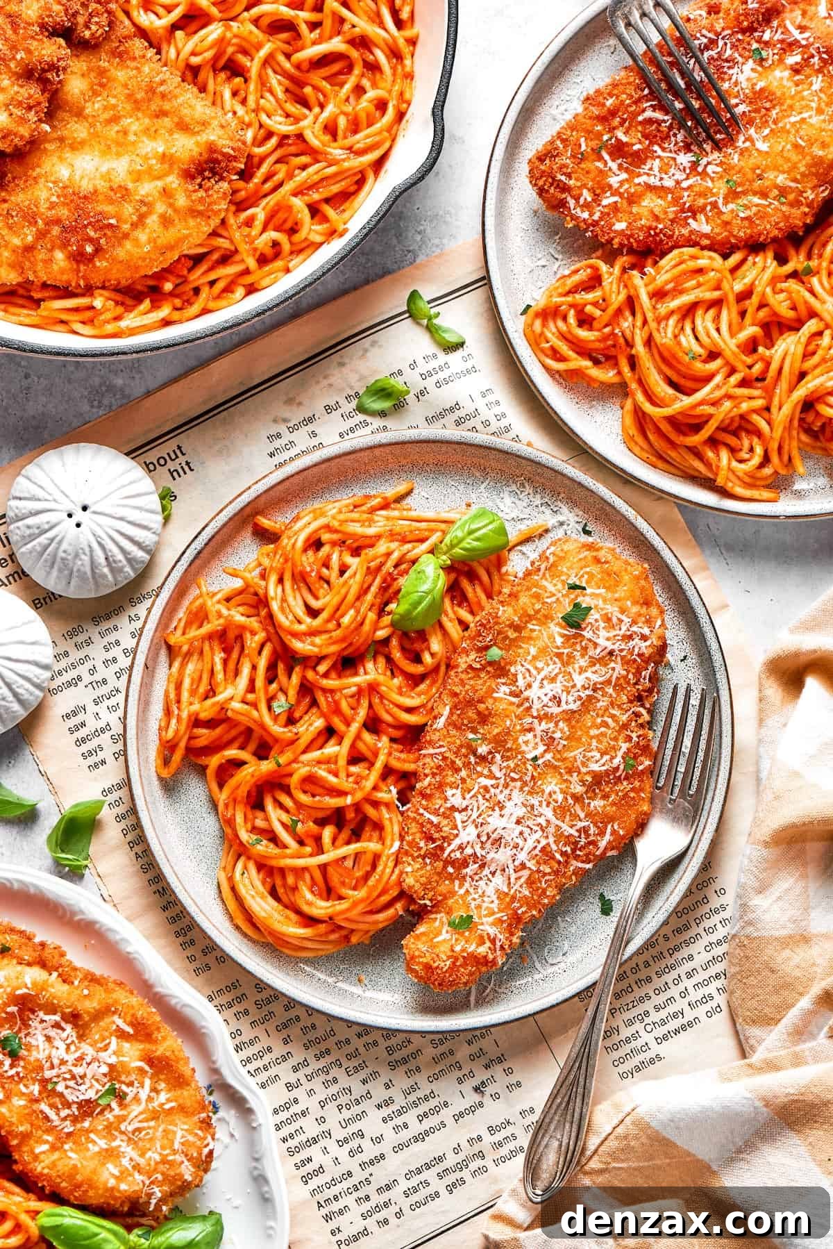 This Cheesecake Factory copycat crusted chicken romano stars crispy, breaded chicken cutlets served on pasta with marinara. Crusted chicken romano is served on plates with pasta.