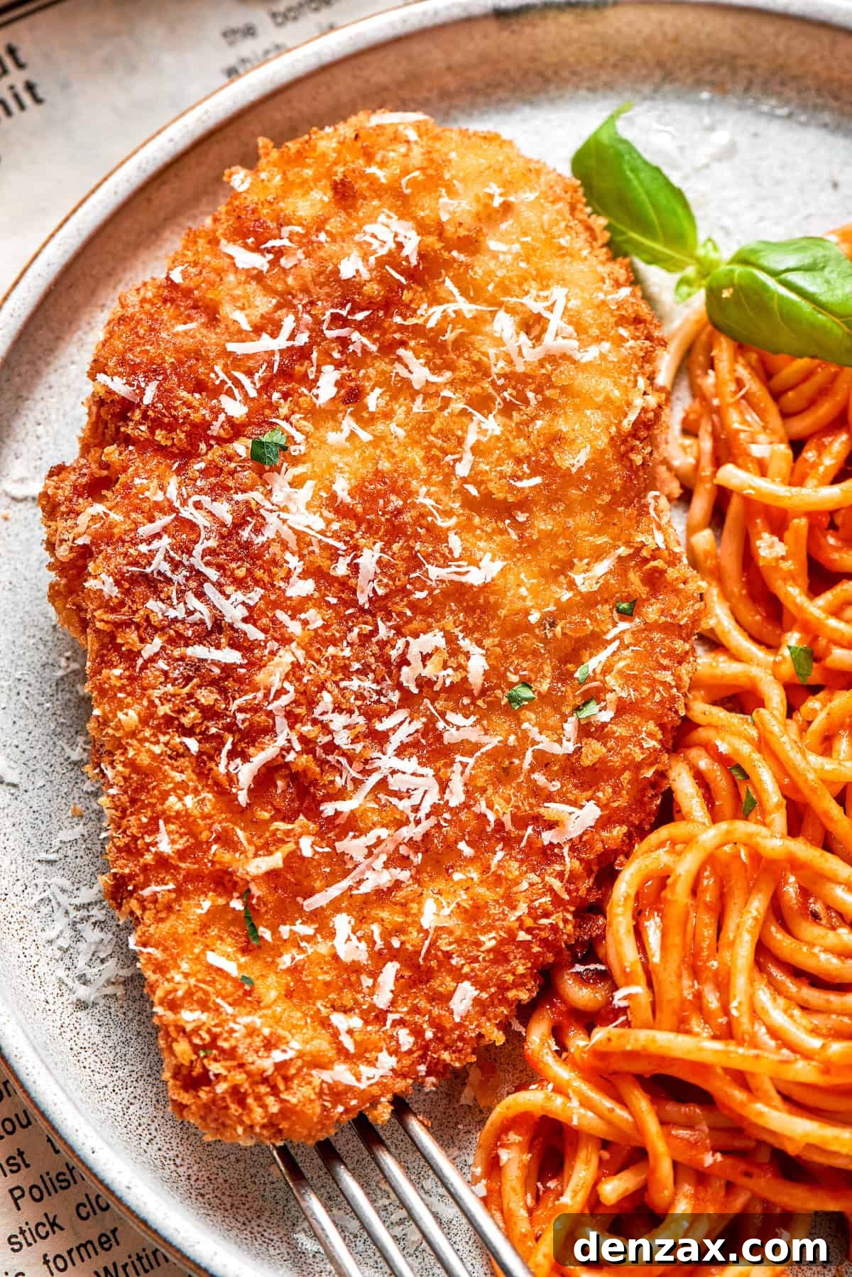 This Cheesecake Factory copycat crusted chicken romano stars crispy, breaded chicken cutlets served on pasta with marinara. A big piece of crusted chicken romano served with spaghetti.