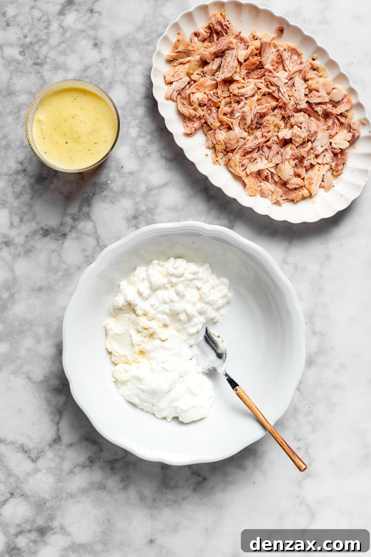 A bowl of flour and a plate of chicken.