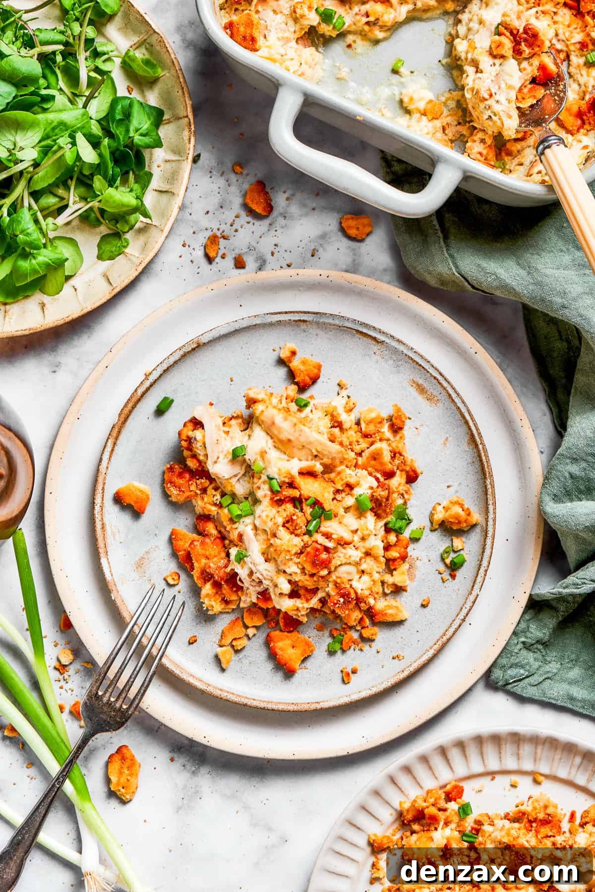 A serving of chicken casserole on a dinner plate with a fork.