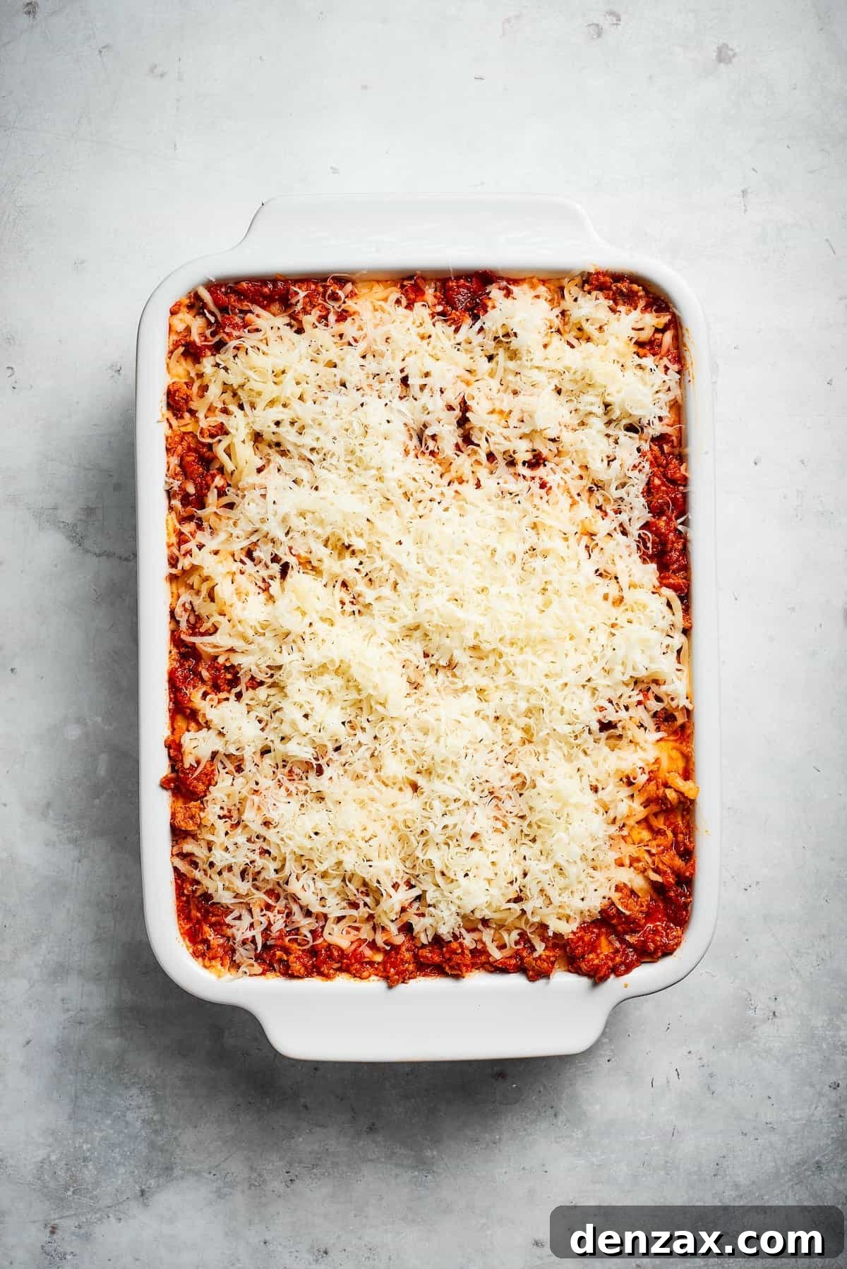 Cheese on top of a pan of beef lasagna.