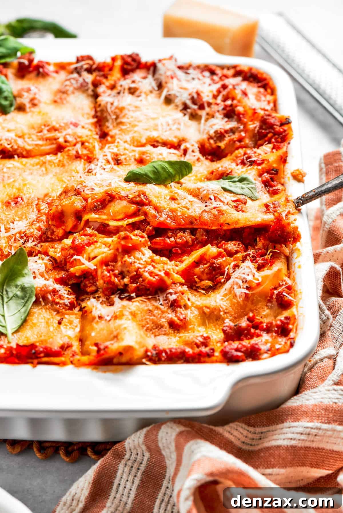 Lifting out a slice of lasagna from a baking dish.