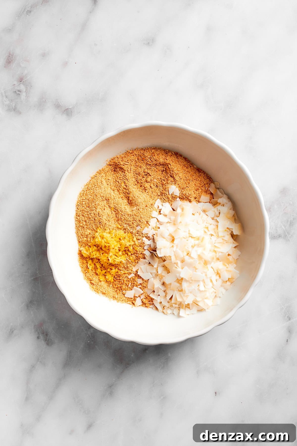 Coconut flakes added to crushed graham crackers.