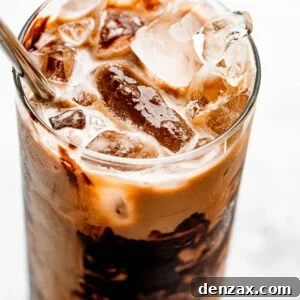 ice floating on top of coffee in a drinking glass