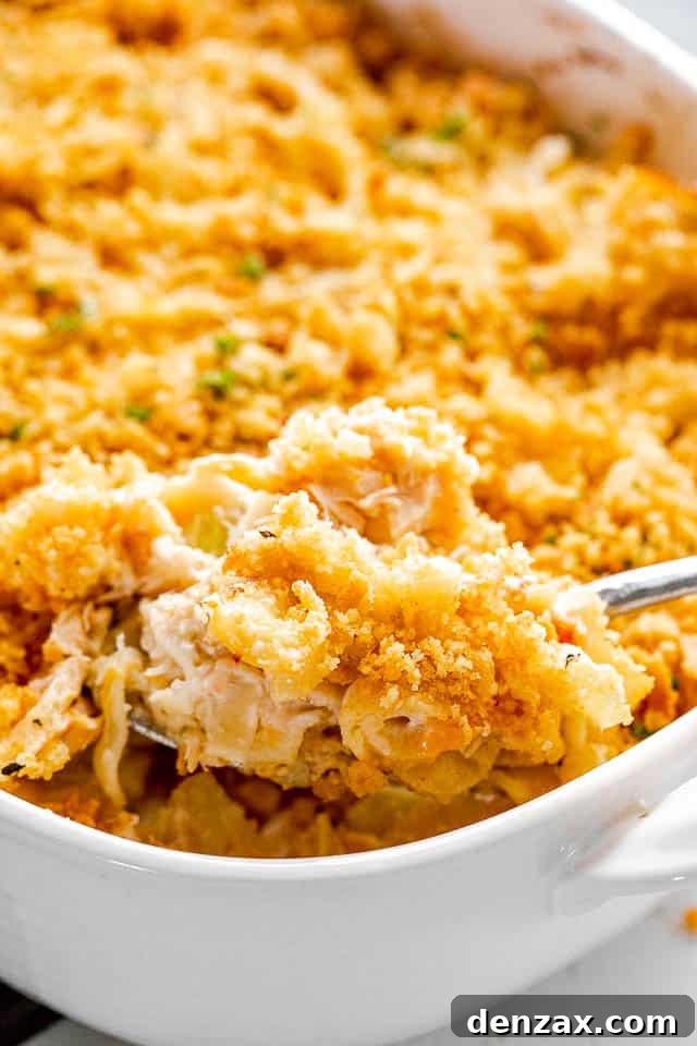 scooping out tuna noodle casserole from baking dish