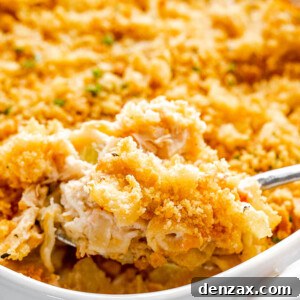 scooping out tuna noodle casserole from baking dish