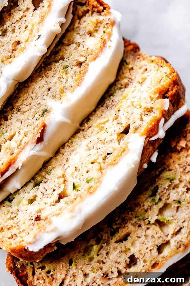 top shot of zucchini bread slices topped with cream cheese frosting