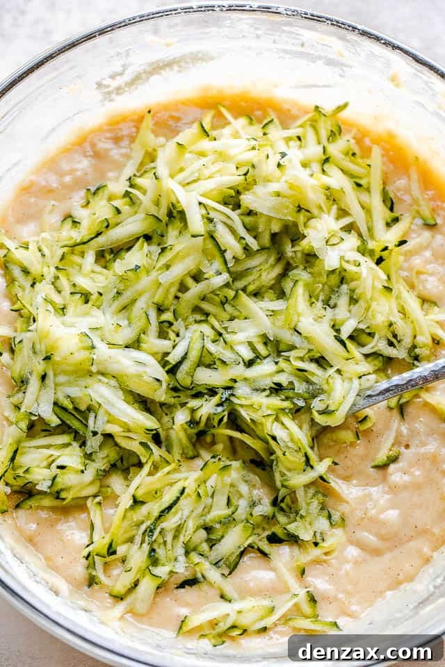 glass mixing bowl with shredded zucchini batter for bread